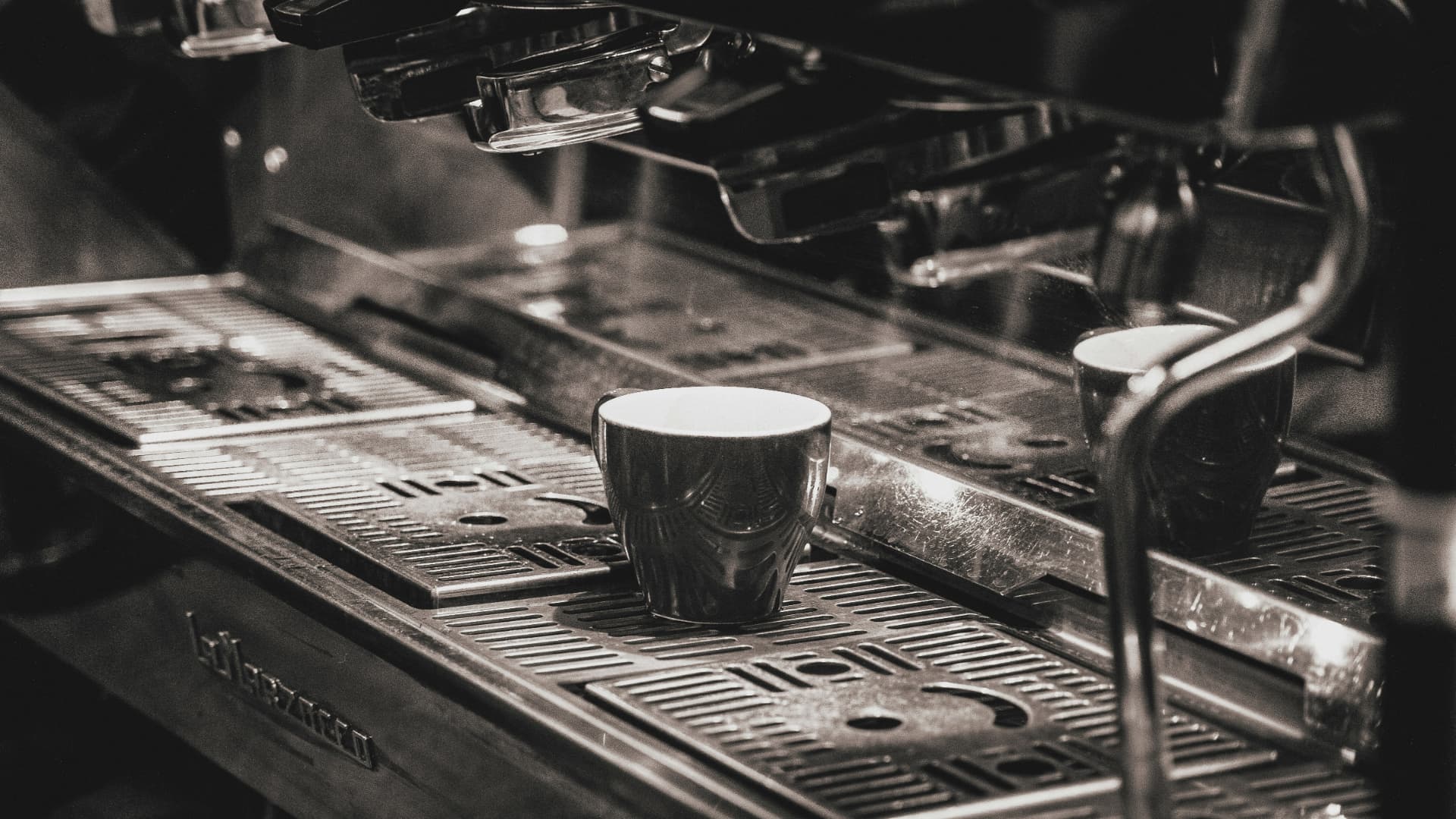 En kopp nybryggt kaffe på ett träbord – vi bjuder på kaffe när vi ses